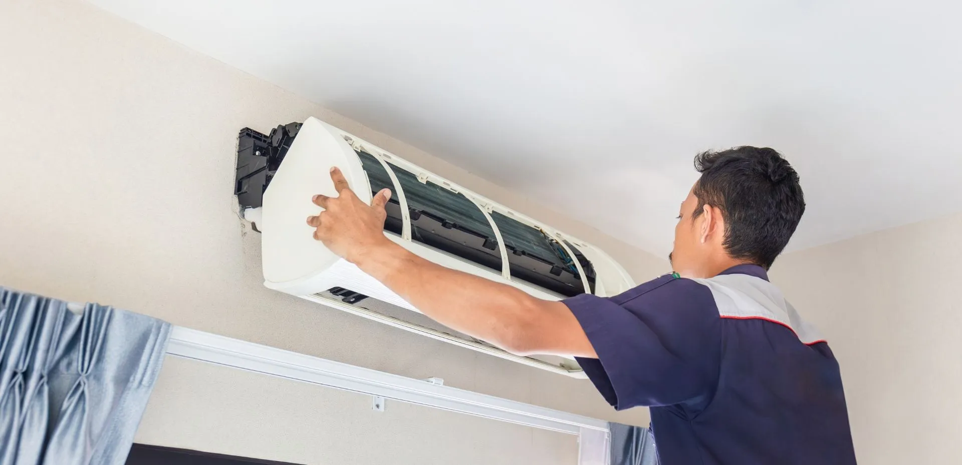 Engineer installing air conditioning unit in London